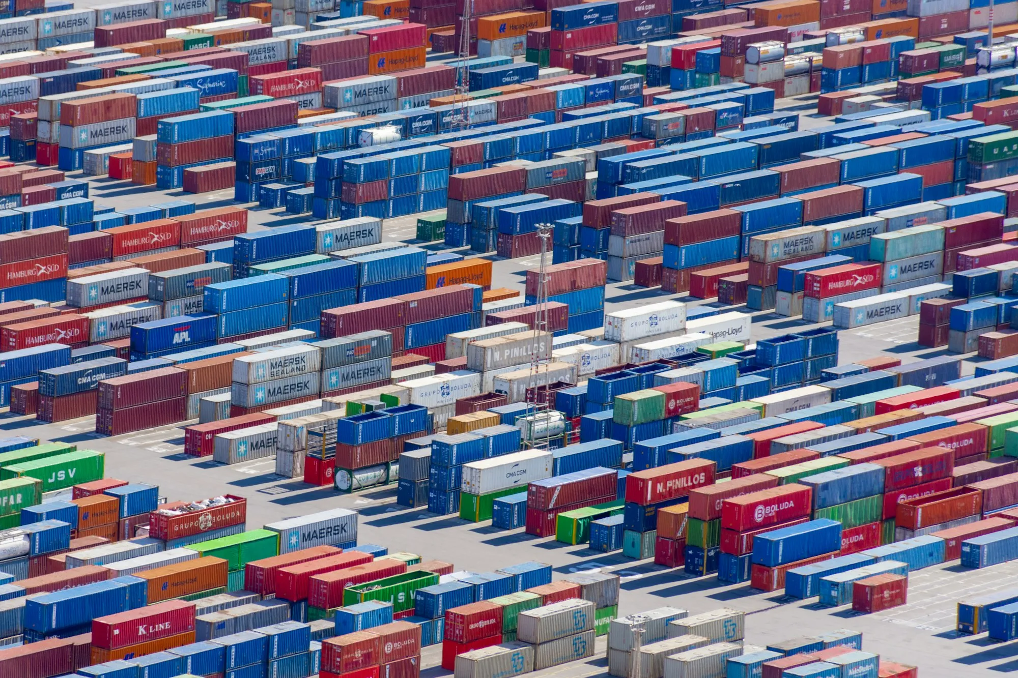 Vista aérea de contenedores de export-import alineados en un patio portuario